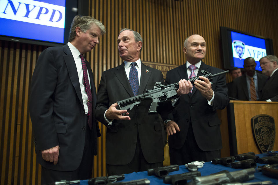 File-This photo from Friday, Oct. 12, 2012, shows District Attorney Cyrus Vance, left, Mayor Michael Bloomberg, center, NYPD Police Commissioner Ray Kelly, right, with confiscated illegal firearm during a press conference in New York. Bloomberg announced in May 2006 that he was suing 15 dealers he accused of selling firearms illegally in other states, resulting in court-appointed monitoring for many targeted shops. (AP Photo/John Minchillo, File)