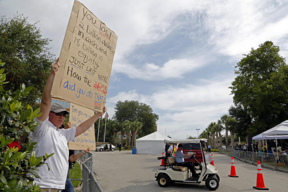 Protestors hold signs outside the gate of JP Morgan Chase annual stockholders meeting held Tuesday, May 15, 2012, in Tampa, Fla. JPMorgan Chase CEO Jamie Dimon, facing shareholders five days after the bank disclosed a $2 billion trading loss, said Tuesday that the company's mistakes were "self-inflicted." (AP Photo/Scott Iskowitz)