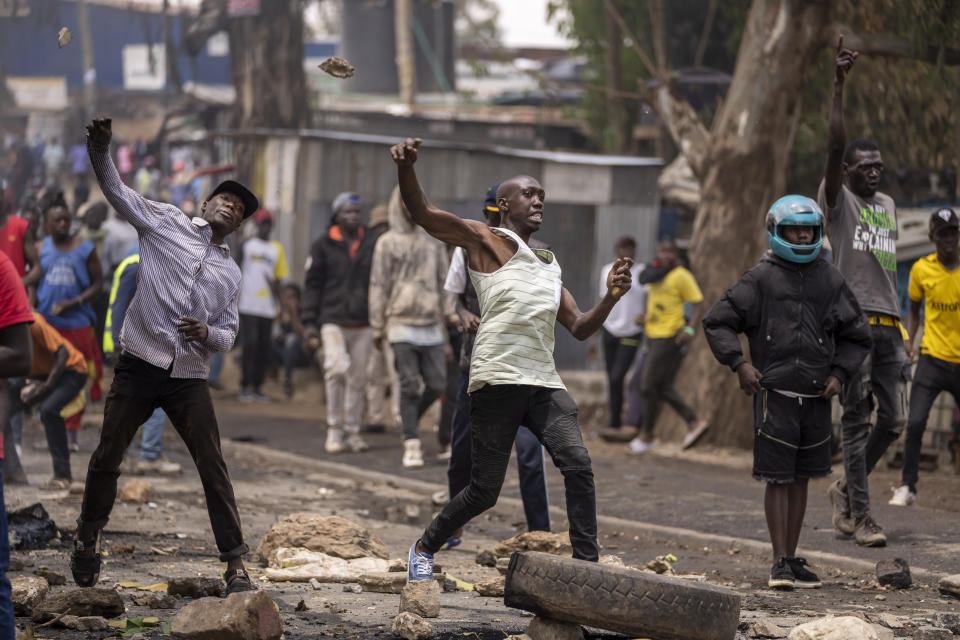 Protesters throw rocks towards police in the Kibera slum of Nairobi, Kenya Monday, March 20, 2023. Hundreds of opposition supporters have taken to the streets of the Kenyan capital over the result of the last election and the rising cost of living, in protests organized by the opposition demanding that the president resigns from office. (AP Photo/Ben Curtis)