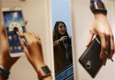 A woman looks at advertisements promoting Samsung Electronics' Galaxy Note 3 smartphone at the company's headquarter in Seoul April 7, 2014. RETUERS/Kim Hong-ji