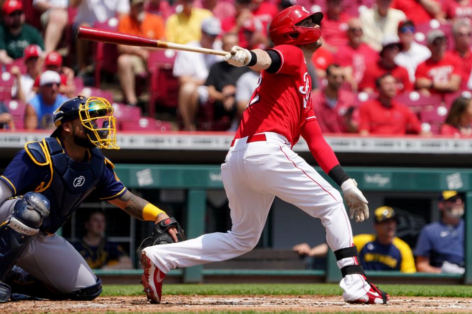 Cincinnati Reds right fielder Tyler Naquin (12) hits a three-run triple in the first inning of a baseball game against the Milwaukee Brewers, Wednesday, May 11, 2022, at Great American Ball Park in Cincinnati. 
