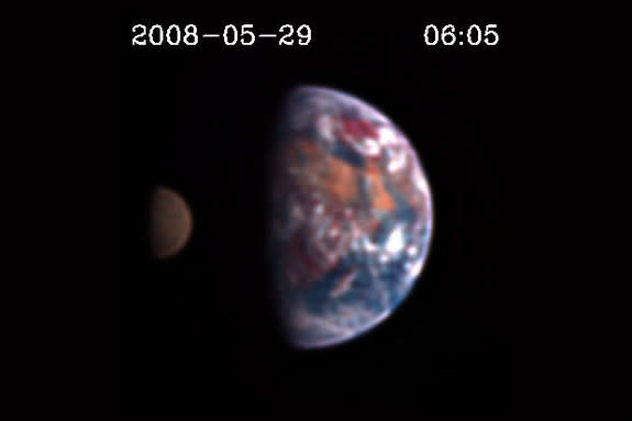 Scientists might one day be capable of discerning land, oceans and clouds on distant planets by looking for reddish, bluish or grayish tints in the color of those worlds. Above is a still image from the EPOXI mission showing the Moon transiting