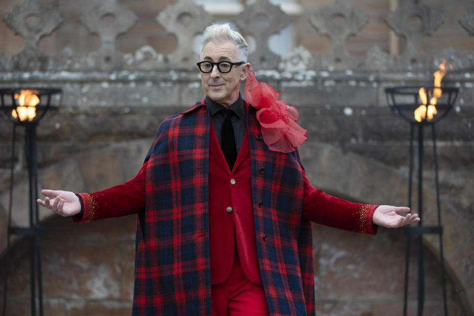 Cumming welcoming the new class of faithfuls — and traitors — to the Scottish castle, wearing red blazer that Spector's assistant, Katie Vaughn, bedazzled to look like the flames of a fire. <p>Photo: Courtesy of NBC Universal</p>