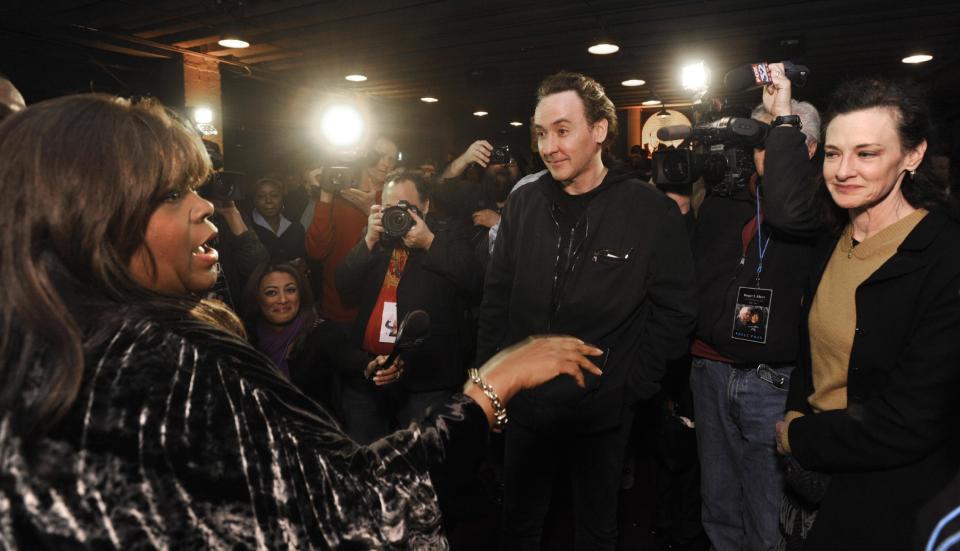 Roger Ebert's wife Chaz Ebert, left, speaks with actors John Cusack center, and Joan Cusack, right, at The Chicago Theater before a memorial for the film critic Ebert in Chicago, Thursday, April 11, 2013. The Pulitzer Prize winning critic died last week at the age of 70 after a long battle with cancer. (AP Photo/Paul Beaty)