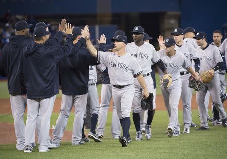 Mar 29, 2018; Toronto, Ontario, CAN; New York Yankees left fielder Brett Gardner (11) celebrates the win at the end of the Toronto Blue Jays home opener at Rogers Centre. Mandatory Credit: Nick Turchiaro-USA TODAY Sports