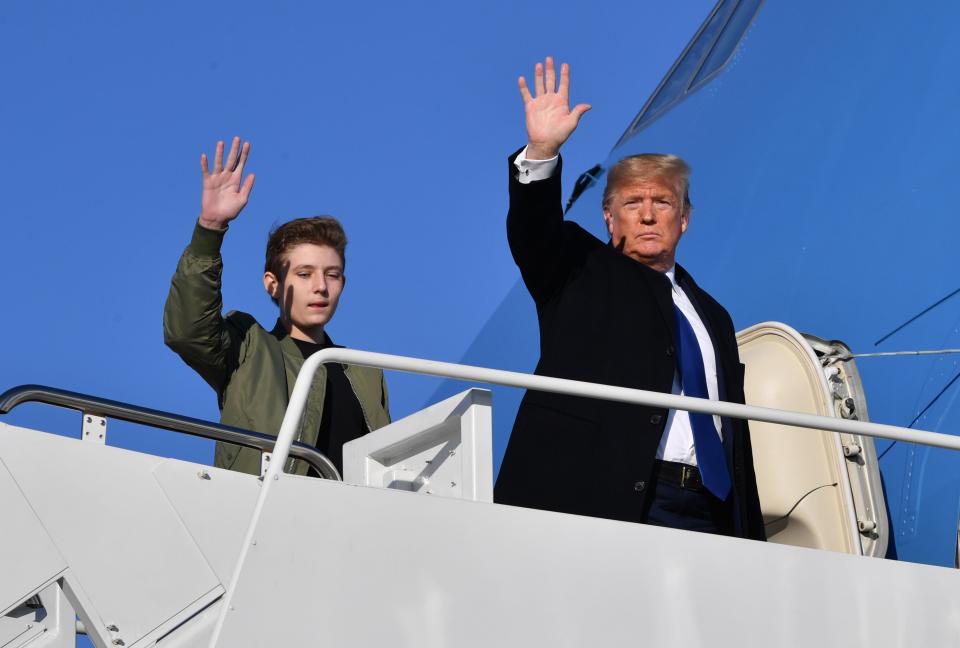 US President Donald Trump and son Barron Trump wave while making their way to board Air Force One at Andrews Airforce Base, Maryland on January 17, 2020. - Trump is traveling to Palm Beach, Florida.