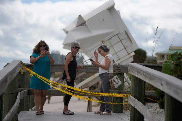People visit the beach to investigate storm damage, including a lifeguard station that was displaced onto a dune, on Thursday in Vero Beach. (Photo: Rebecca Blackwell via Associated Press)
