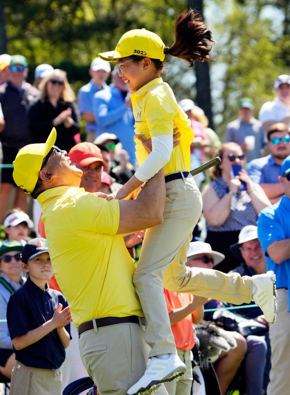 Ashley Kim is hoisted into the air by her father, Harry, after winning the girls 7-9 division of the Drive, Chip and Putt finals on Sunday at Augusta National Golf Club,.