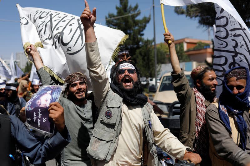 Taliban members rejoice on the second anniversary of the fall of Kabul on a street near the US embassy in Kabul