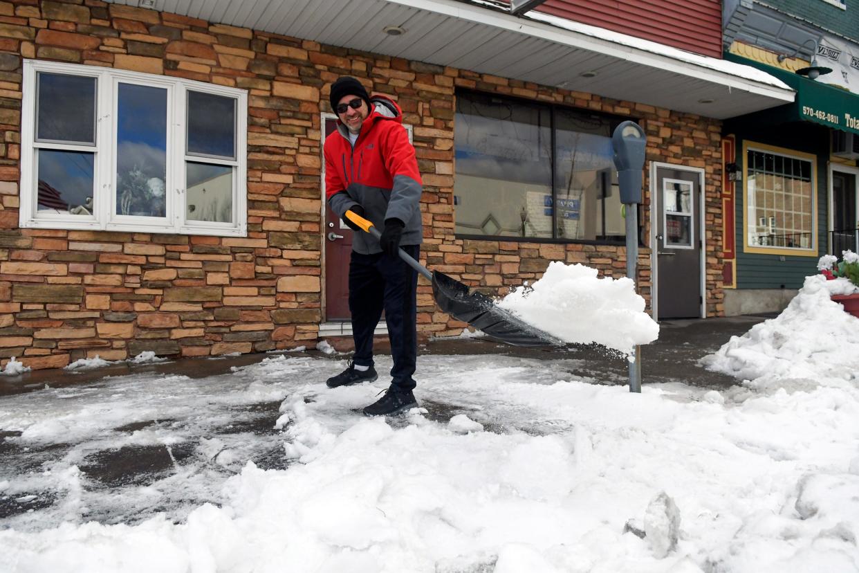 Steve Vernalis shovels snow from the sidewalk in front of his restaurant Vernalis Restaurant on South Main Street in Shenandoah, Pa., on Tuesday, Jan. 18, 2022.