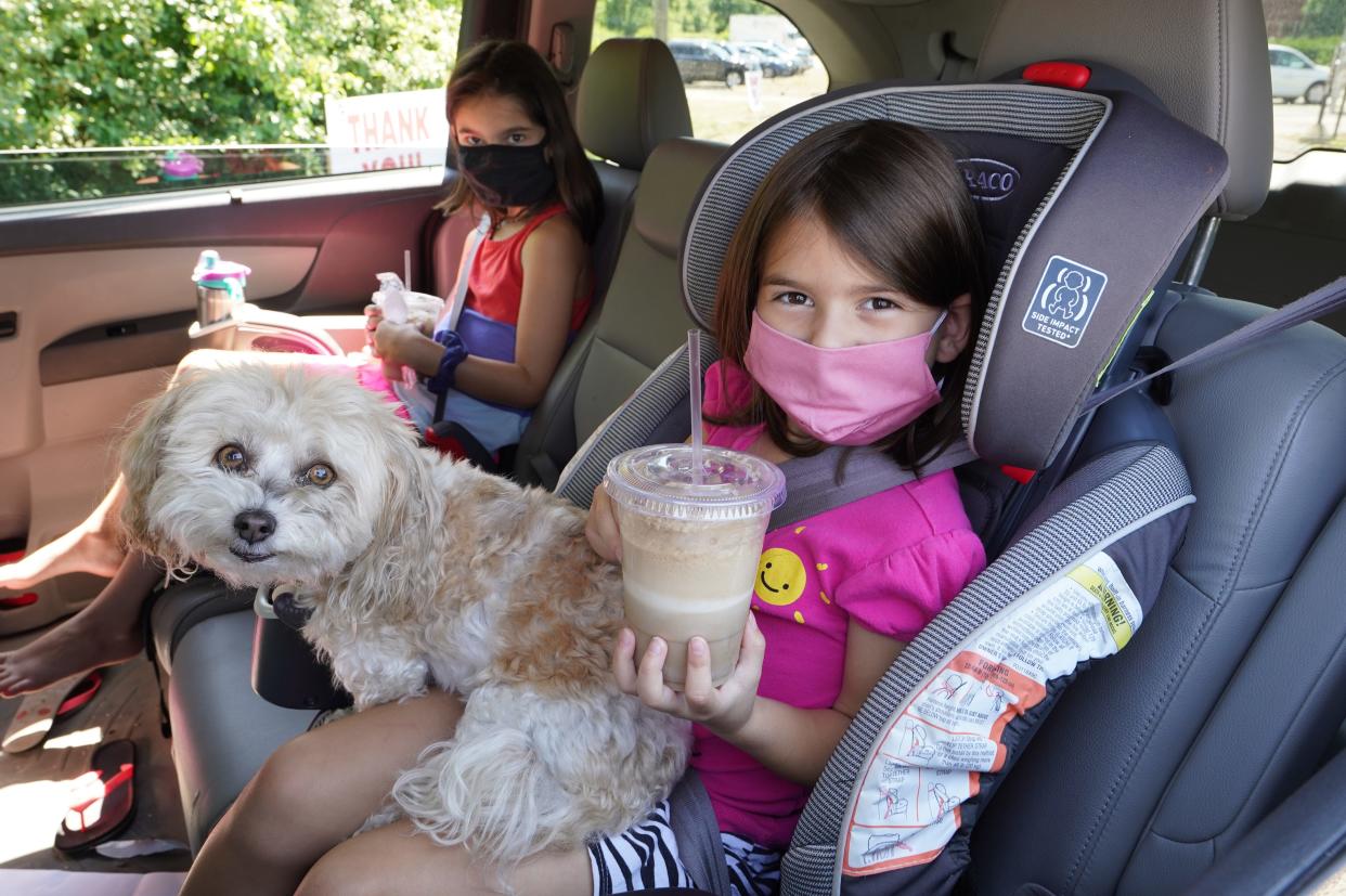 Daphne Steinmetz, 5, holds her free root beer float next to her sister, Addie, 8, and their dog, Amy, during National Root Beer Float Day at Sprecher Brewing in Glendale on Aug. 6, 2020. This year's giveaway is also planned for Aug. 6.