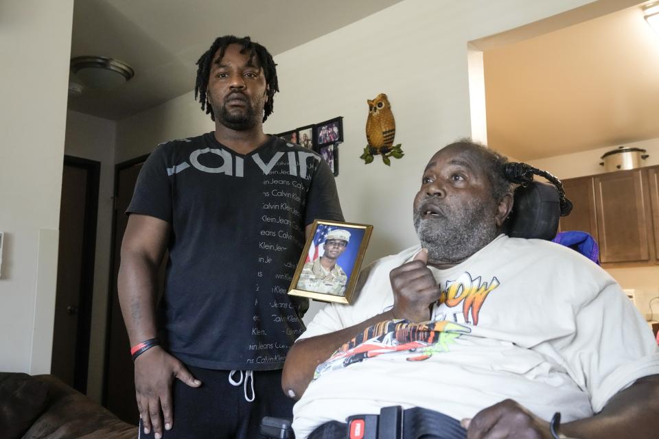 Carl Gates, grandfather of Travis King, and Myron Gates, uncle of King, pose with a photo of Pvt. King.