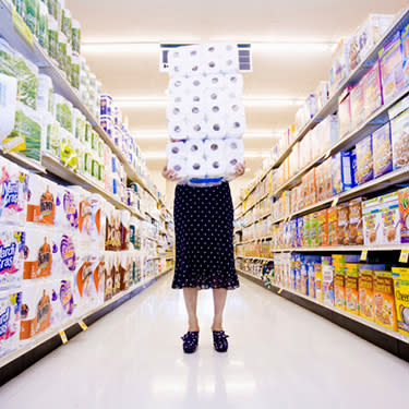 Woman-carrying-stack-of-toilet-paper-in-supermarket_web