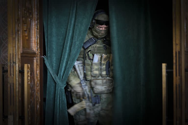 Un soldado ruso, en una abertura con cortinas en la Cámara Filarmónica de Mariupol, en el territorio que está bajo el control del Gobierno de la República Popular de Donetsk, en el este de Ucrania, el domingo 12 de junio de 2022. Esta foto fue tomada durante un viaje organizado por el Ministerio de Defensa de Rusia. (AP Photo)