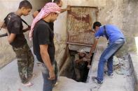 A Free Syrian Army fighter helps a fellow fighter get out of a tunnel in the old city of Aleppo September 10, 2013. REUTERS/Molhem Barakat