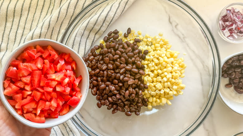 adding tomatoes to a bowl