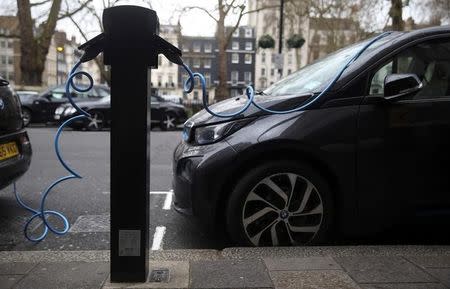 Electric cars are plugged into a charging point in London, Britain, April 7, 2016. REUTERS/Neil Hall/Files