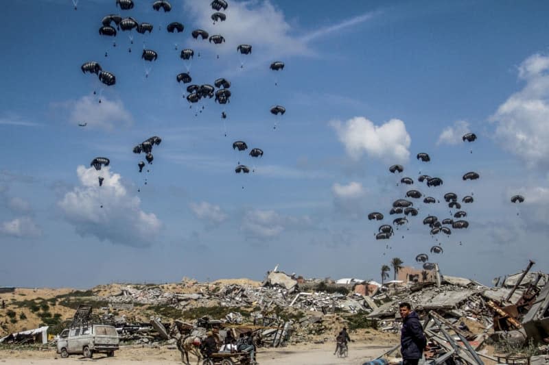 Parachutes carrying humanitarian aid dropped from aircraft, land on Jabalia in northern Gaza Strip, where civilians are said to be on the verge of famine. Mahmoud Issa/dpa