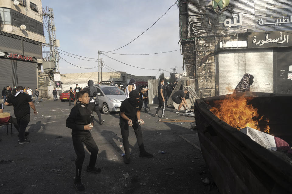 Palestinians clash with Israeli security forces in Shuafat refugee camp in Jerusalem, Wednesday, Oct.12. 2022. Israeli police have been operating in the Shuafat refugee camp in Jerusalem's eastern sector to hunt for a suspect in a deadly shooting attack at a checkpoint on Sunday that killed a soldier. (AP Photo/Mahmoud Illean)