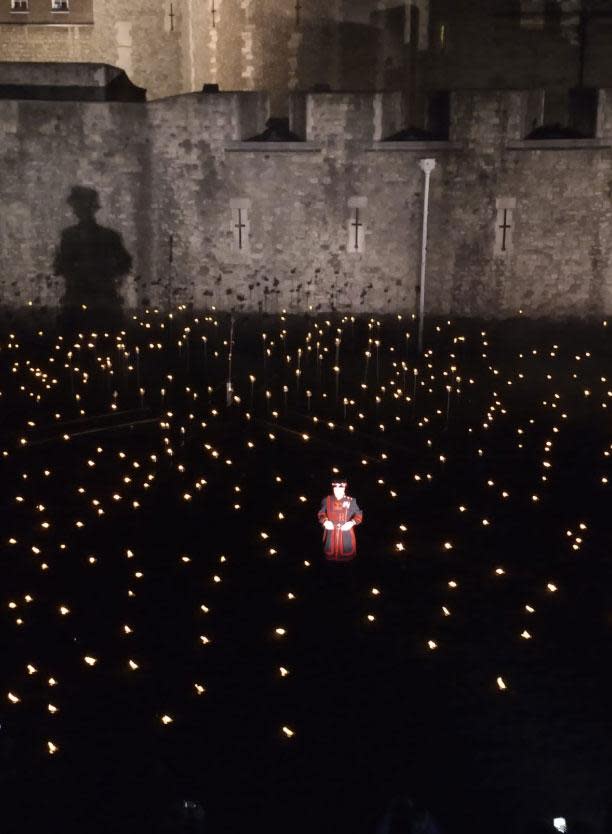 A beefeater stands among the flames in the Tower of London's moat (Gavin Goodhart)