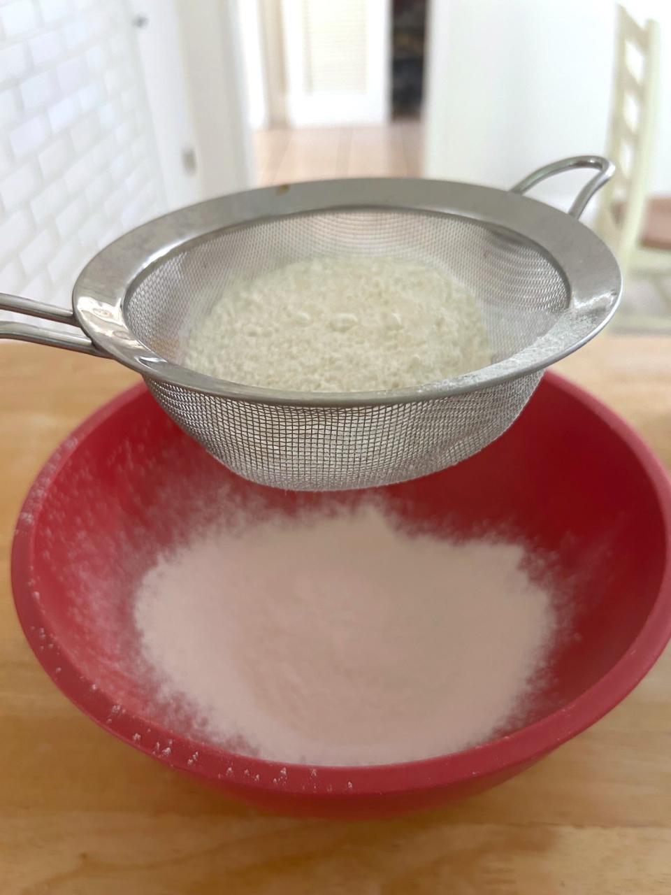 Sifting the dry ingredients for Ina Garten's chocolate cake with mocha frosting