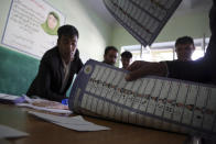 Afghan election workers count ballots during the parliamentary elections, at a polling station in Kabul, Afghanistan, Sunday, Oct. 21, 2018. The elections entered a second day after delays caused by violence and technical issues, as a roadside bomb killed nearly a dozen civilians on Sunday, including several children. (AP Photo/Rahmat Gul)