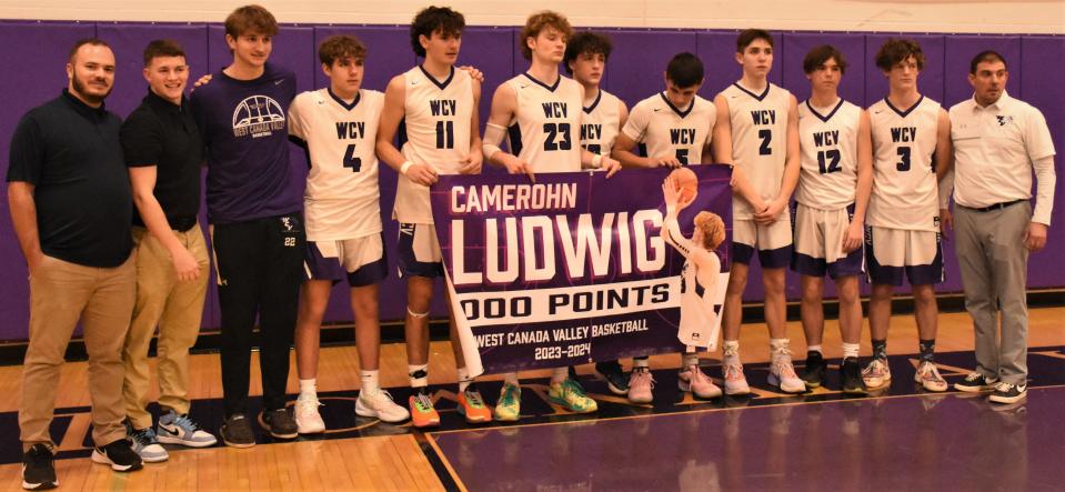 Camerohn Ludwig (23) poses with his West Canada Valley teammates after after scoring the 1,000th point of his varsity career Thursday.