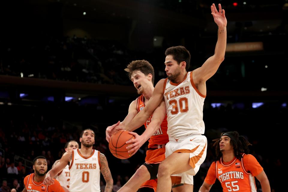 Illinois forward Matthew Mayer and Texas' Brock Cunningham fight for a rebound during the first half of their game at Madison Square Garden.