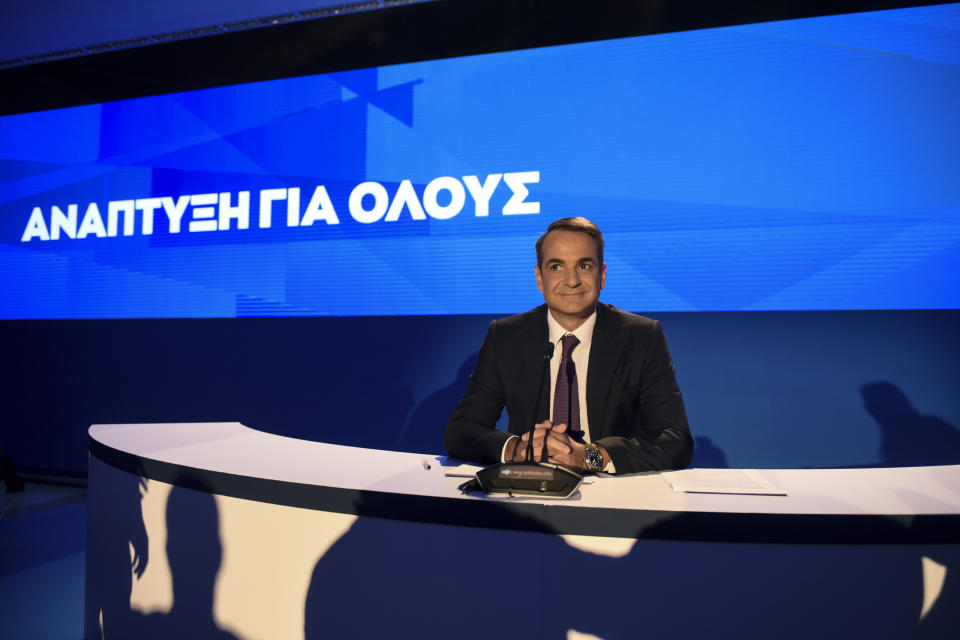 Greece's Prime Minister Kyriakos Mitsotakis waits for a news conference to start during the Thessaloniki International Fair at the northern city of Thessaloniki, Sunday, Sept. 8, 2019. Greece's prime minister said on Saturday that financial reforms such as reducing taxes, fighting bureaucracy and attracting investment must be implemented before the country asks its creditors to agree to lower budget surpluses. The slogan reads : "Growth for all". (AP Photo/Giannis Papanikos)