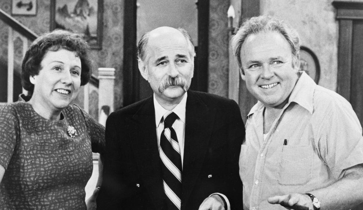Producer Norman Lear on the set of his hit TV series 'All In The Family,' standing between its stars, Jean Stapleton and Carroll O'Connor. <a href="https://www.gettyimages.com/detail/news-photo/left-to-right-is-actor-jean-stapleton-producer-norman-lear-news-photo/1835678866?adppopup=true" rel="nofollow noopener" target="_blank" data-ylk="slk:Bettmann Archive/Getty Images;elm:context_link;itc:0;sec:content-canvas" class="link "> Bettmann Archive/Getty Images</a>