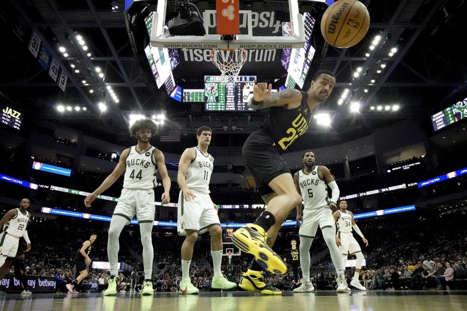 Utah Jazz's John Collins tries to save a ball from going out of bounds during the second half of an NBA basketball game against the Milwaukee Bucks Monday, Jan. 8, 2024, in Milwaukee. The Jazz won 132-116. (AP Photo/Morry Gash)