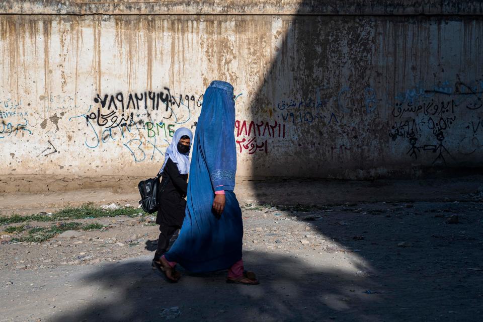 An Afghan woman and a girl walk to a primary school in Kabul.