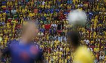 Fans watch as Dirk Kuyt of the Netherlands (L) fights for the ball with Brazil's Oscar during their 2014 World Cup third-place playoff at the Brasilia national stadium in Brasilia July 12, 2014. REUTERS/Ueslei Marcelino (BRAZIL - Tags: SOCCER SPORT WORLD CUP TPX IMAGES OF THE DAY)