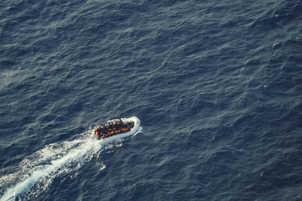 African migrants attempting to cross the Mediterranean Sea from Libya to Italy in a rubber boat Tuesday, Oct. 5, 2021, look up at the Seabird, a humanitarian aircraft flying over them. At least 23,000 people have died or disappeared trying to reach Europe since 2014, according to the United Nations' migration agency. Despite the risks, many migrants say they'd rather die trying to reach Europe than be returned to Libya. (AP Photo/Renata Brito)