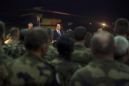 French President Francois Hollande (C) speaks with French soldiers after he paid tribute to two French soldiers who were killed overnight, in Bangui, December 10, 2013. REUTERS/Fred Dufour/Pool