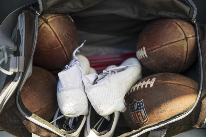 A detailed view of Adam Botkin's footballs and cleats before a film session for a TikTok video at Washington-Grizzly Stadium in Missoula, Mont., on Monday, May 1, 2023. (AP Photo/Tommy Martino)