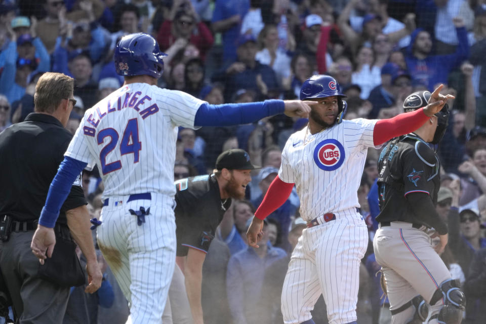 Chicago Cubs' Cody Bellinger and pinch runner Nelson Velazquez acknowledge Nick Madrigal after they scored on Madrigal's single during the eighth inning of a baseball game against the Miami Marlins on Saturday, May 6, 2023, in Chicago. The Cubs won 4-2. (AP Photo/Charles Rex Arbogast)