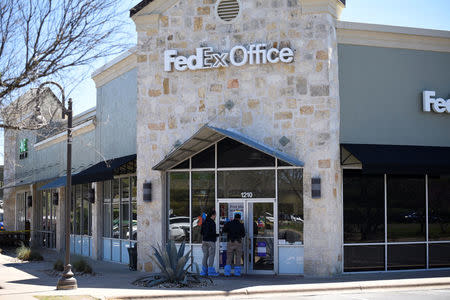 Law enforcement personnel are seen gathering evidence outside a FedEx Store which was closed for investigation, in Austin, Texas, U.S., March 20, 2018. REUTERS/Sergio Flores
