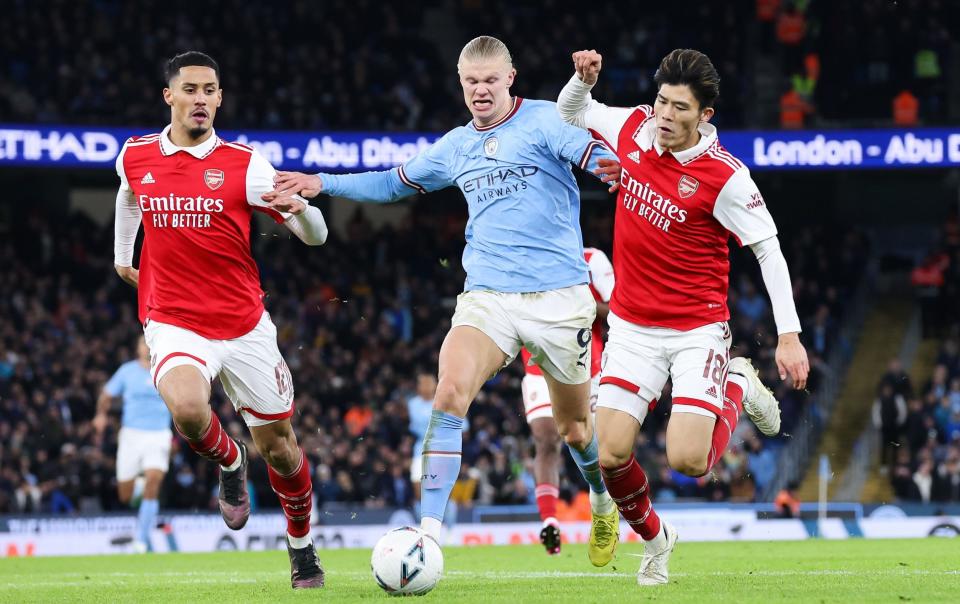 rling Haaland of Manchester City battles for possession with William Saliba and Takehiro Tomiyasu of Arsenal during the Emirates FA Cup Fourth Round match between Manchester City and Arsena - Getty Images/Alex Livesey