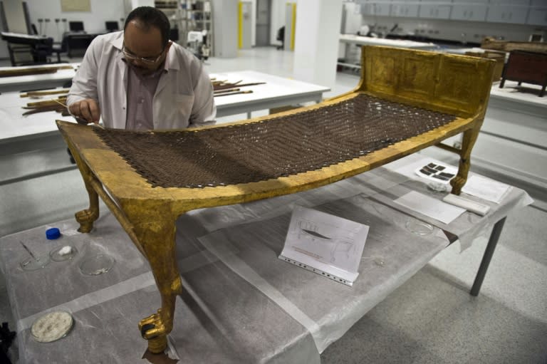 Archaeologist Medhat Abdallah, cleans a gold-plated bed from Tutankhamen's treasures at the new Grand Egyptian Museum near the Giza pyramids in Cairo on June 4, 2015