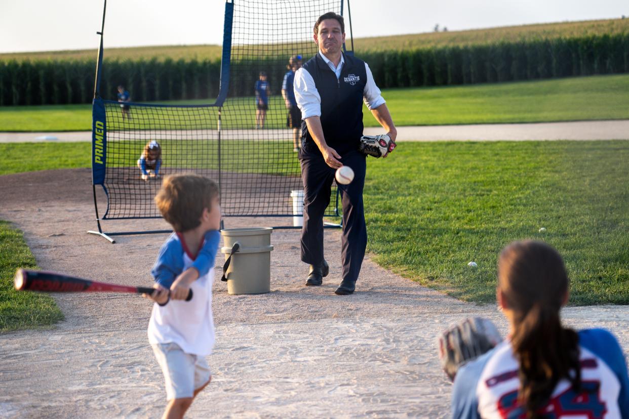 Gov. Ron DeSantis pitches to his son Mason as his wife Casey plays catcher during an event at the Field of Dreams movie site on Thursday, August 24, 2023 in Dyersville.