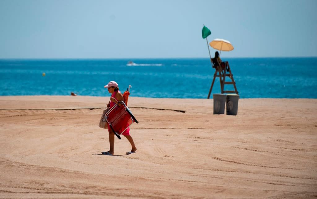 A sunseeker returns to a beach in Spain - getty