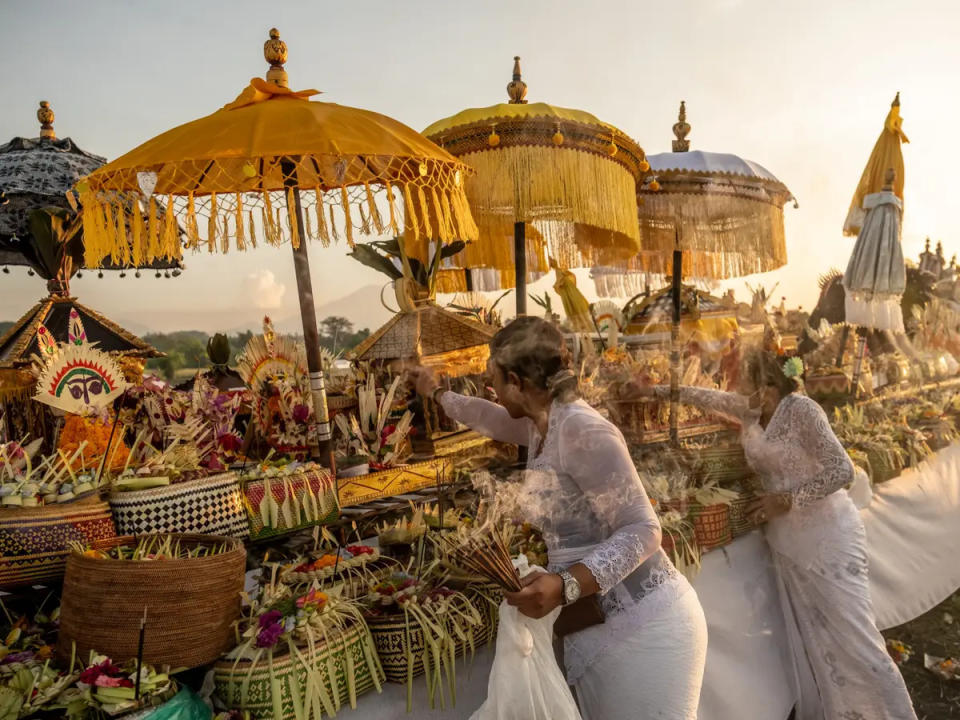 Eine balinesische Frau legt während des Melasti-Rituals vor dem Nyepi-Tag Weihrauch nieder.  - Copyright: Agung Parameswara/Getty Images