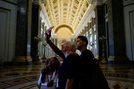 Tourists take a selfie inside the Capitol in Havana, Cuba, April 17, 2018. Picture taken April 17, 2018. REUTERS/Alexandre Meneghini