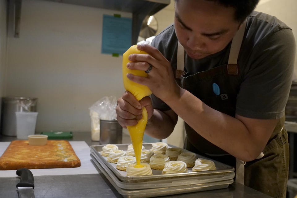 Pastry chef Vince Bugtong prepares Yema cakes, a salted egg cake with almond yogurt and salted egg yolk custard, at Abaca restaurant in San Francisco, Monday, May 15, 2023. Three Filipino restaurants in three different areas of the U.S. will be representing at this year's James Beard Awards, the culinary world's equivalent of the Oscars. The awards ceremony is next week in Chicago. (AP Photo/Jeff Chiu)