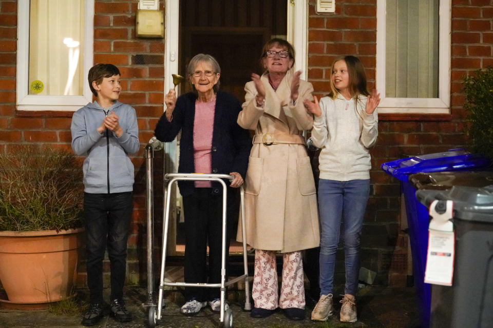 MANCHESTER,  - MARCH 26: Barbara Leigh, aged 93, (second left) rings a bell for the NHS, with her family who are all staying together throughout the lockdown, from their front garden across the road from Wythenshawe Hospital on March 26, 2020 in Manchester, United Kingdom. The "Clap For Our Carers" campaign has been encouraging people across the U.K to take part in the nationwide round of applause from their windows, doors, balconies and gardens at 8pm to show their appreciation for the efforts of the NHS as they tackle the coronavirus (COVID-19). The coronavirus pandemic has spread to many countries across the world, claiming over 20,000 lives and infecting hundreds of thousands more. (Photo by Christopher Furlong/Getty Images)