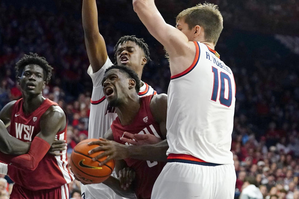 Washington State's TJ Banba (5) is fouled as he drives between a double-team by Arizona's Adama Bal, second from left and Azuolas Tubelis (10) during the first half of an NCAA college basketball game, Saturday, Jan. 7, 2023, in Tucson, Ariz. (AP Photo/Darryl Webb)