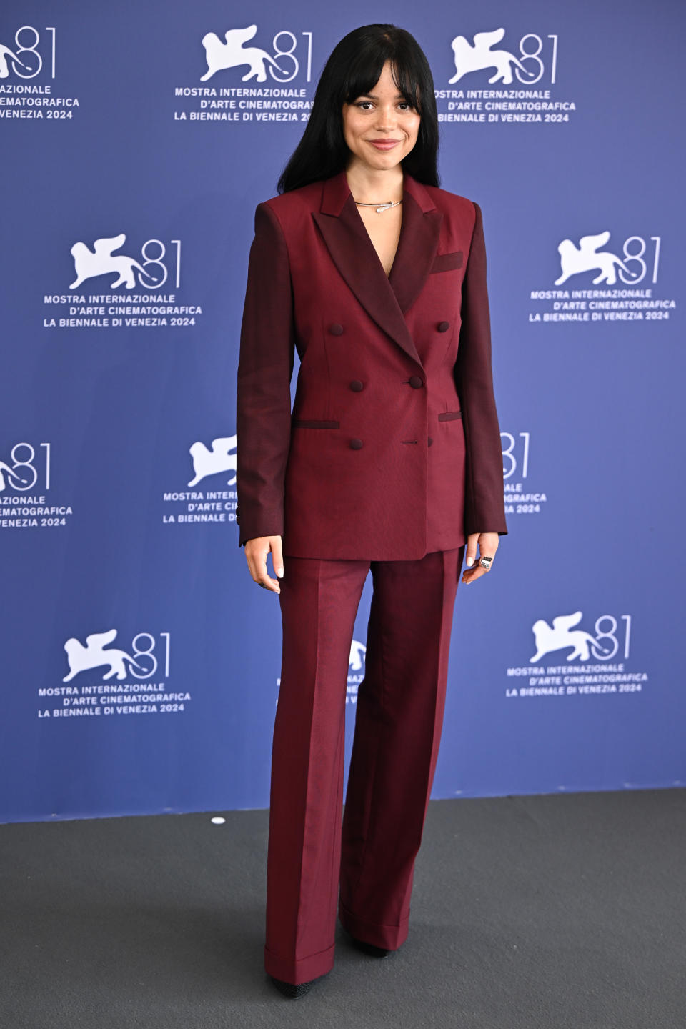 Jenna Ortega in a burgundy two-piece suit at the Venice International Film Festival