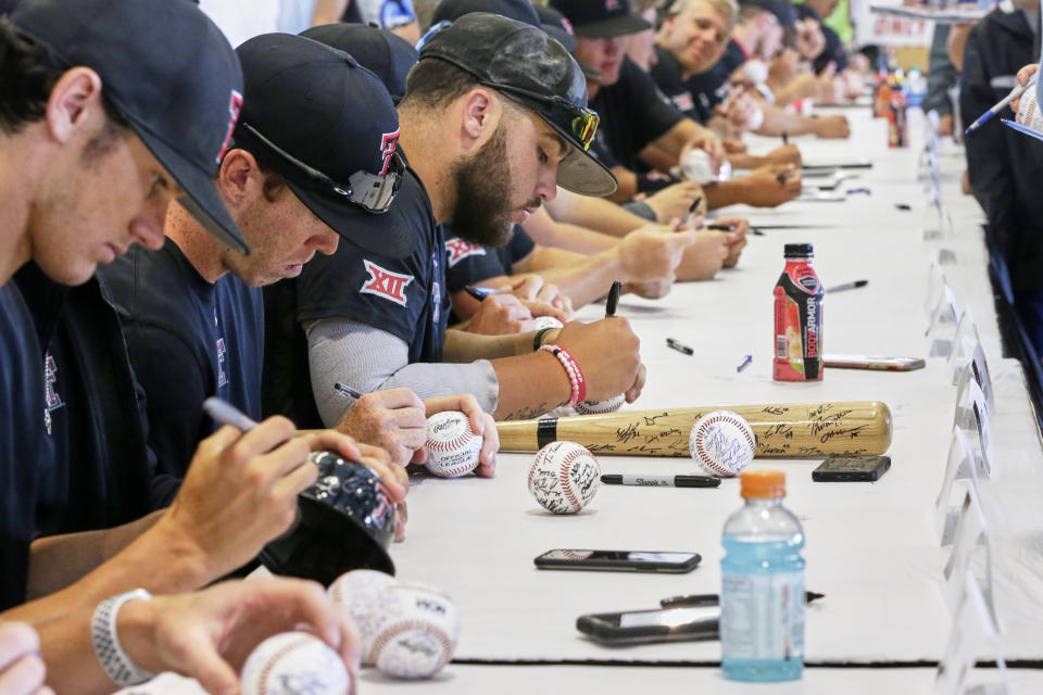 Texas Tech NCAA college baseball players sign autographs for fans following practice at TD Ameritrade Park in Omaha, Neb., Friday, June 14, 2019. Texas Tech plays Michigan on Saturday in the College World Series. (AP Photo/Nati Harnik)