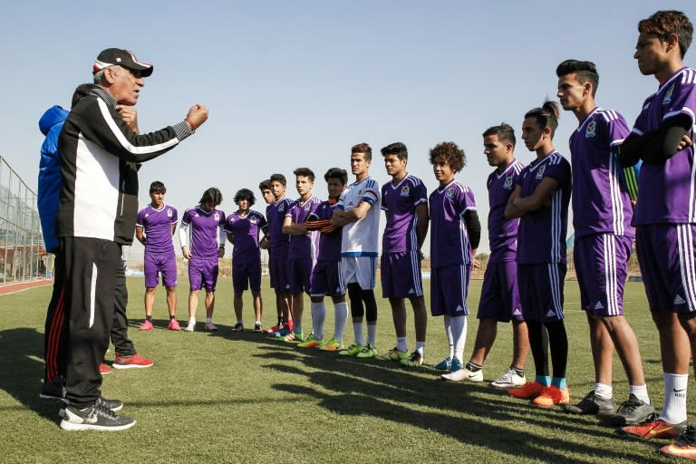 Iraqi football coach Kadhim Flayeh uses an electro-larynx and sign language to train his players